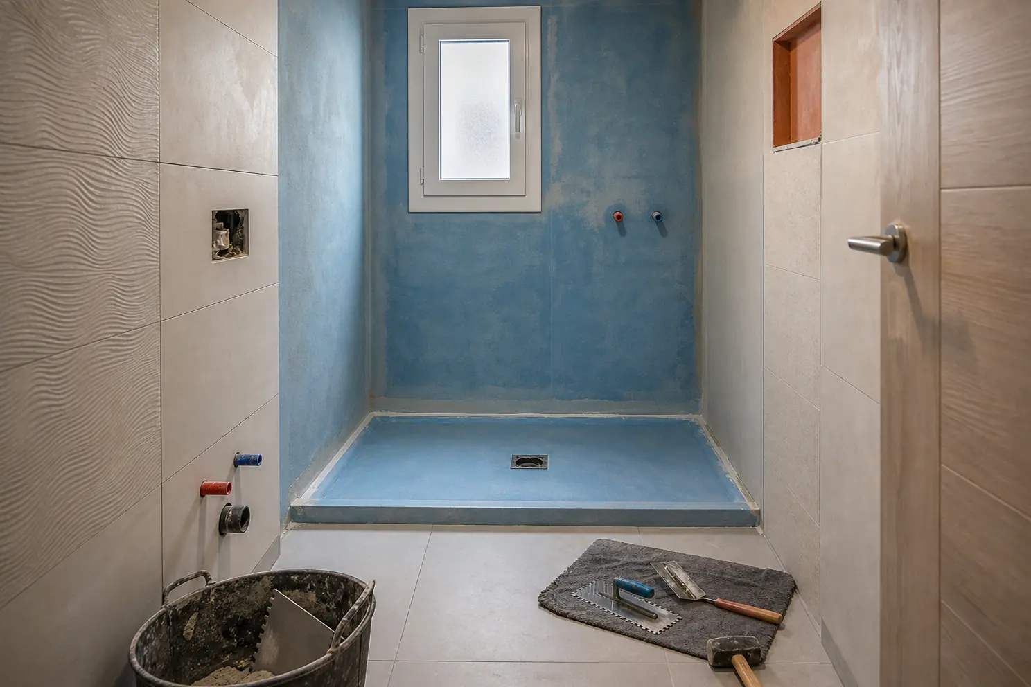 Zona de ducha impermeabilizada con puntos de agua preparados.